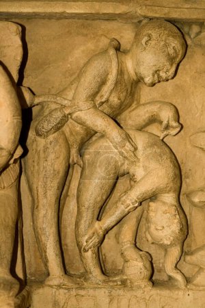 Erotic sculpture of loving couple in animal posture circa tenth century at Lakshmana temple of Khajuraho , Madhya Pradesh , India