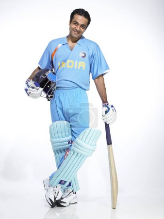 Indischer Schlagmann hält Schläger und Helm für Cricket-Match bereit