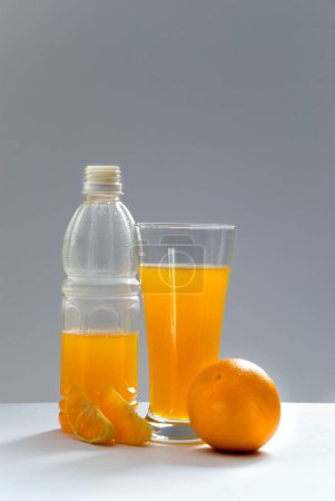 Foto de Beber, una cáscara de fruta naranja con jugo en botella y vaso - Imagen libre de derechos