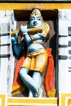 Bunt bemalte Statue von Lord Krishna, der Flöte spielt Bansuri an der Fassade des Sri Ranganathswami Tempelkomplexes, Srirangam, Tiruchirapalli Trichy, Tamil Nadu, Indien