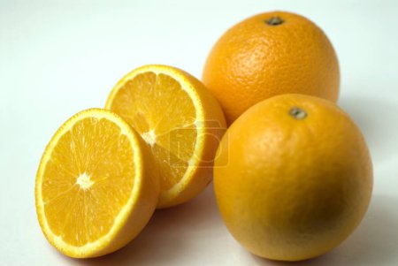 Foto de Cítricos redondos de fruta naranja pocos cortados en medio fondo blanco - Imagen libre de derechos