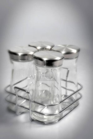 Foto de Cosas de cocina, cuatro frascos de especias vacías sobre fondo gris - Imagen libre de derechos