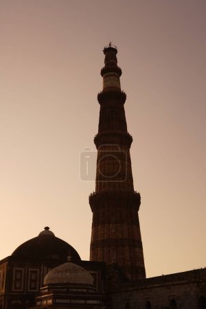 Photo for Sunset at Alai Darwaza Imam Zamins tomb and Qutab Minar built in 1311 red sandstone tower , Indo_Muslim art , Delhi sultanate , Delhi, India UNESCO World Heritage Site - Royalty Free Image