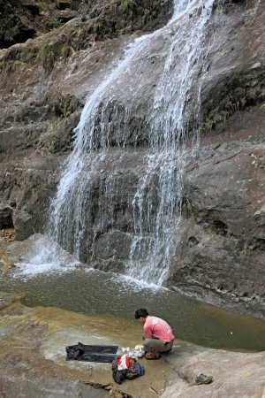 Photo for Tribal man washing his clothes near waterfall , Cherrapunji , Meghalaya , India - Royalty Free Image