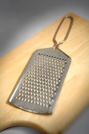 Kitchen things , cheese grater on wooden board