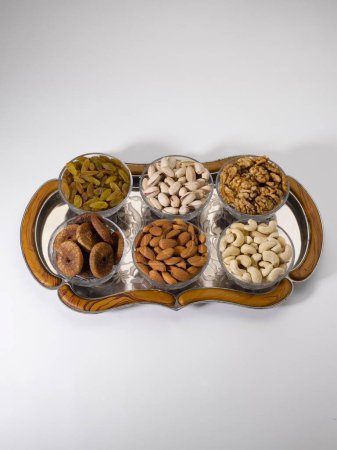 Photo for Dry fruits and nuts , almonds pistachios walnuts raisins figs cashew nuts in bowls on tray - Royalty Free Image