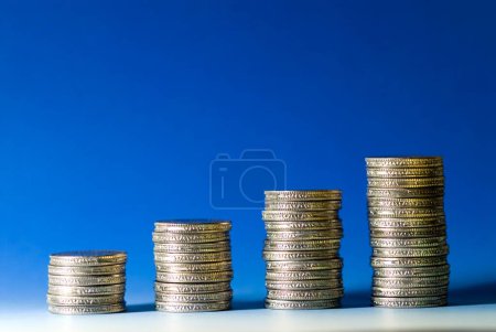 Konzept, Wachstum Indische Fünf-Rupien-Münzen stapelweise auf blauweißem Hintergrund