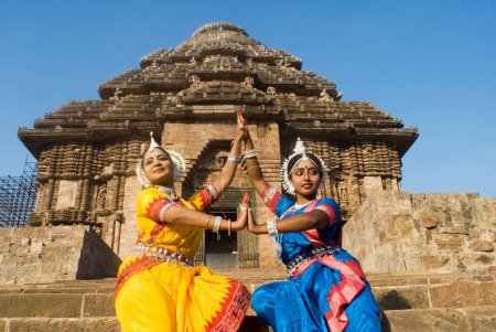 Téléchargez les photos : Les danseurs Odissi posent et reproduisent des mythes indiens tels que le Ramayana devant le complexe du temple solaire du patrimoine mondial à Konarak, Orissa, Inde - en image libre de droit