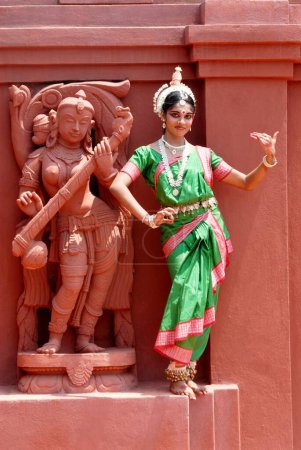 Téléchargez les photos : Femme exécutant la danse traditionnelle classique Odissi à la statue sur scène - en image libre de droit