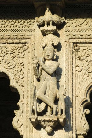Téléchargez les photos : Krishna payant flûte sculptée dans la pierre sur le mur du temple Maheshwar, Maheshwar, Madhya Pradesh, Inde - en image libre de droit