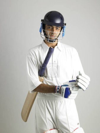 Indischer Schlagmann mit Handschuhen bereitet sich auf Cricket-Match vor 