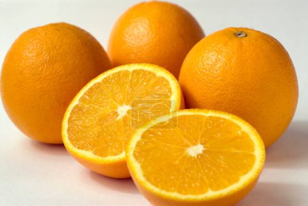 Téléchargez les photos : Agrumes ronds orange peu coupés en demi fond blanc - en image libre de droit