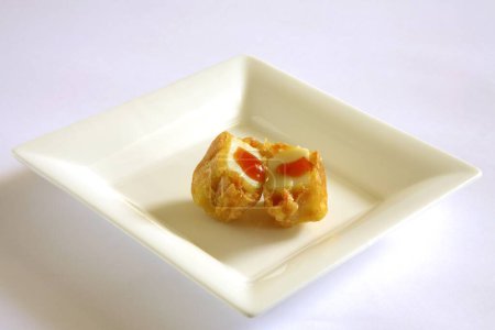 Téléchargez les photos : Cuisine indienne, entrées fast-food Cheese Pakode puffs servi avec ketchup tomate dans un plat sur fond blanc - en image libre de droit
