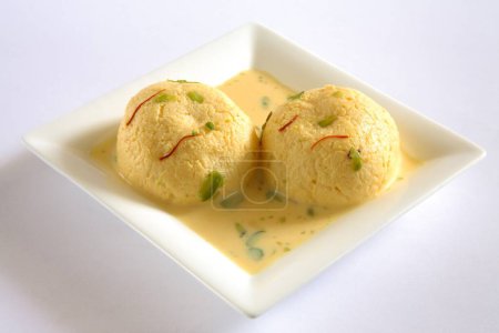 Indian sweet , kesar rasmalai garnish with pistachio and saffron served in plate