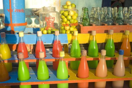 Botellas de vidrio llenas de jarabes aromatizados en el puesto de bebidas frías en Dakor temple cerca de Anand, Gujarat, India