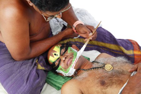 Téléchargez les photos : Maquillage appliqué sur le visage du danseur kathakali sud-indien, Kerala, Inde - en image libre de droit