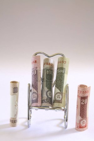 Foto de Concept Indian currency ten twenty and fifty rupees and one hundred five hundred on relax stainless steel chair - Imagen libre de derechos