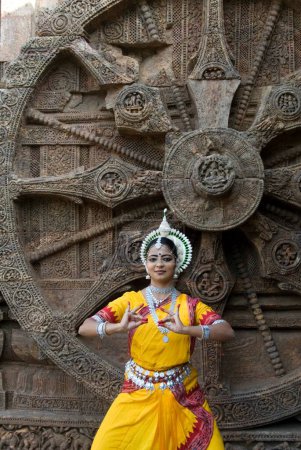 Foto de Bailarines de Odissi posan representan mitos indios como el Ramayana frente al icónico carruaje del sol en el complejo del templo del sol de la herencia de mundo en Konarak, Orissa, India - Imagen libre de derechos