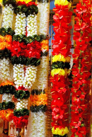 Foto de Guirnaldas coloridas de flores artificiales cuelgan para la venta utilizadas para la decoración del festival Ganpati, Dadar, Bombay Mumbai, Maharashtra, India - Imagen libre de derechos