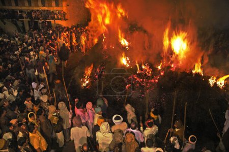 Photo for Holi engulfed in flames and people gathered around at village of Phalen ; Uttar Pradesh ; India - Royalty Free Image
