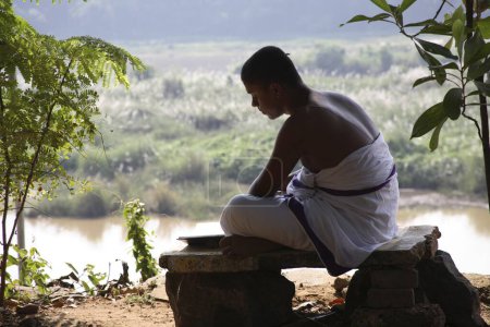 Téléchargez les photos : Sri Sadvidya Sanjivini Rigveda Pathshala, jeunes étudiants en études religieuses apprenant par cœur Vedas assis dans une posture asana près du temple Shankarchaya et Sharda sur la rive de la rivière Poorna, Kaldi, Kerala, Inde - en image libre de droit