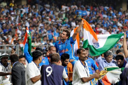 Téléchargez les photos : Le batteur indien Sachin Tendulkar est porté sur les épaules par ses coéquipiers alors qu'il agite le tricolore après que l'Inde a vaincu le Sri Lanka lors de la finale de la Coupe du monde de cricket 2011 de l'ICC disputée au stade Wankhede à Mumbai, en Inde - en image libre de droit