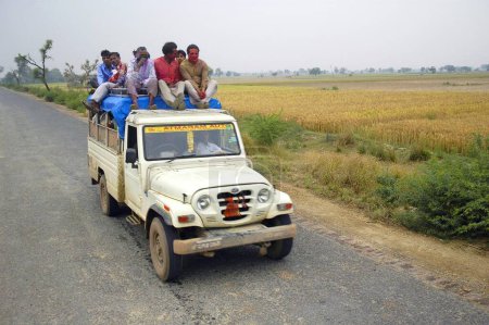 Téléchargez les photos : Jeep surpeuplée avec des gens assis sur le dessus allant pour le festival Holi, Govardhan, Uttar Pradesh, Inde - en image libre de droit