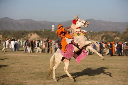 Foto de Nihang o Sikh guerrero a caballo durante la celebración de Hola Mohalla en Anandpur sahib en el distrito de Rupnagar, Punjab, India - Imagen libre de derechos