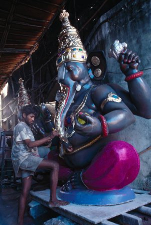 Téléchargez les photos : Festival Ganesh ganpati, couleur noire et marron Éléphant dirigé Dieu, homme faisant le travail de finition - en image libre de droit