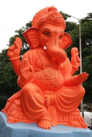 Bright orange coloured idol of lord Ganesh ; the elephant headed God ; Pune ; Maharashtra ; India