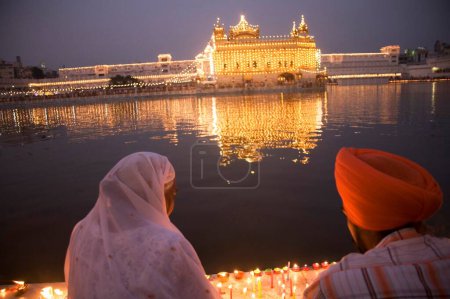 Téléchargez les photos : Couple sikh assis près de l'eau bénite, décoration du festival Heri Mandir Sahib Dussera, temple Swarn Mandir Golden, Amritsar, Punjab, Inde - en image libre de droit