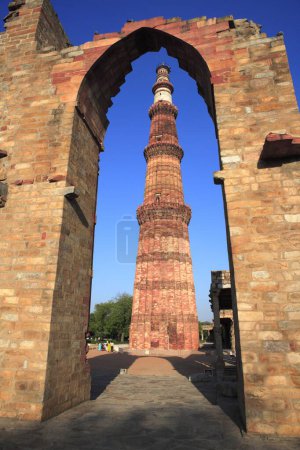 Photo for Qutb Minar through arch built in 1311 red sandstone tower , Indo-Muslim art , Delhi sultanate , Delhi, India UNESCO World Heritage Site - Royalty Free Image
