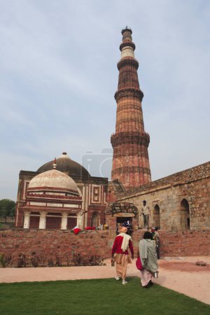 Indische Sadhu beobachten Qutb Minar 1311 erbaut rotem Sandstein Turm, indo-muslimische Kunst, Sultanat Delhi, Delhi, Indien UNESCO-Weltkulturerbe