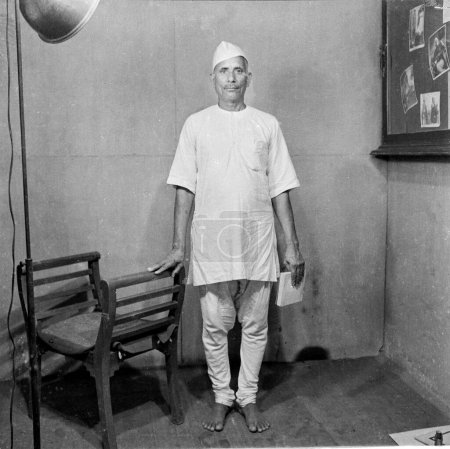 Foto de Viejo vintage 1900 s negro y blanco estudio retrato de indio hombre usando blanco kurta pijama topi cap India 1940 - Imagen libre de derechos