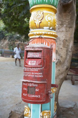 Téléchargez les photos : Boîte aux lettres rouges de la poste indienne accrochée à un pilier décoratif à Sri Kalahasti ; Andhra Pradesh ; Inde - en image libre de droit