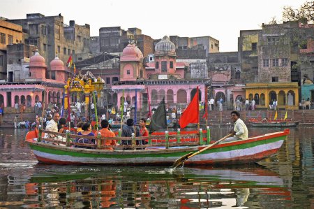 Téléchargez les photos : Pèlerins en bateau devant des temples colorés sur les rives de la rivière Yamuna, Vishram Ghat, Mathura, Uttar Pradesh, Inde - en image libre de droit
