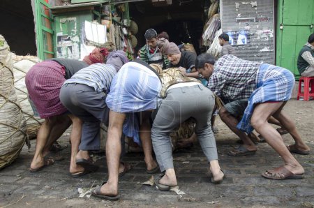 Téléchargez les photos : Travailleurs soulevant des balles lourdes sur la route Kolkata Bengale occidental Inde Asie - en image libre de droit