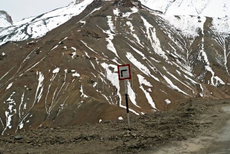 Turn right signboard with snowy Himalayan mountain ; Ladakh ; Jammu and Kashmir ; India 9-April-2008