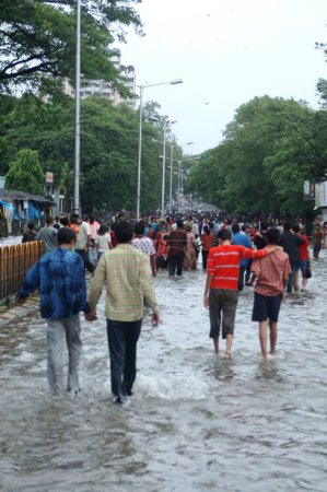 Foto de Inundación debido a fuertes lluvias, mostrando a la gente caminando en agua de lluvia acumulada, Monzón, lluvia récord mundial en carretera desde Jambhali Naka a Thane Station, junto a Masoonda Talao, Shivaji Path, Thane, Maharashtra, India - Imagen libre de derechos