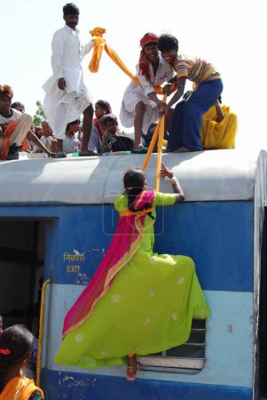 Téléchargez les photos : Hommes traînant une femme par turban sur le toit d'un train à la gare, Jodhpur, Rajasthan, Inde - en image libre de droit