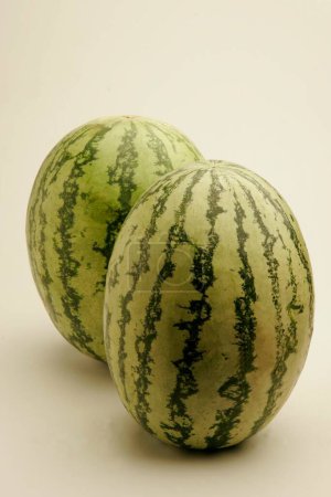 Photo for Fruits ; Two full watermelons with light and dark green stripes watery and red from inside ; Pune; Maharashtra ; India - Royalty Free Image