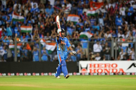 Téléchargez les photos : Le batteur indien Gautam Gambhir lève sa batte après avoir complété 50 manches lors de la finale de la Coupe du monde de cricket entre l'Inde et le Sri Lanka au stade Wankhede à Mumbai le 2 avril 2011 - en image libre de droit