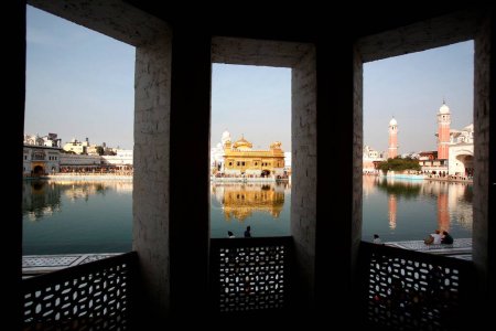Blick auf Harmandir Sahib oder Darbar Sahib oder Goldener Tempel umgeben von See zusammen mit Uhrturm Ramgarhia Bunga in Amritsar; Punjab; Indien