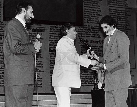 Téléchargez les photos : L'acteur indien Kabir Bedi et le réalisateur Prakash Mehra remettent le prix Observer à Amitabh Bachchan en 1992 - en image libre de droit