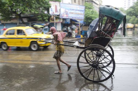 Photo for Man pulling Hand Rickshaw with passenger on street in Kolkata at West Bengal India Asia - Royalty Free Image