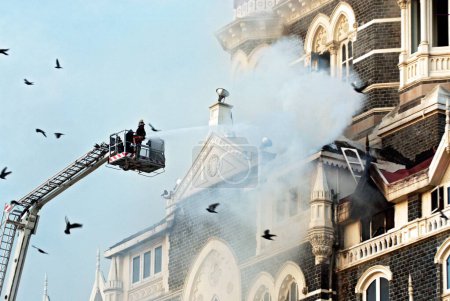 Photo for Fire fighters try to douse fire inside of Taj Mahal hotel after terrorist attack by deccan mujahedeen on 26th November 2008 in Bombay Mumbai, Maharashtra, India - Royalty Free Image