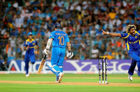 Photo for Indian batsman Sachin Tendulkar walk back to pavilion as Sri lankan bowler Lasith Malinga R celebrates his wicket during the 2011 ICC World Cup Final between India and Sri Lanka at Wankhede Stadium on April 2 2011 in Mumbai India - Royalty Free Image