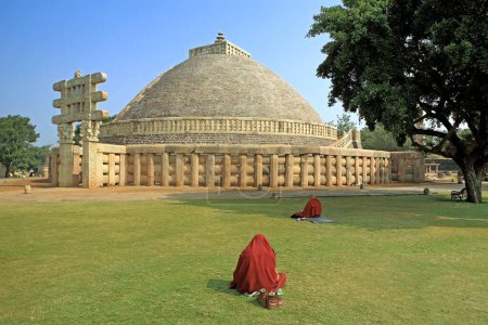 Photo for Buddhist monk reading scriptures in front of Stupa 1 constructed by king Ashok, Sanchi , Madhya Pradesh, India - Royalty Free Image