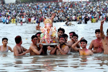 Photo for Devotees immerse a huge Ganesh idol elephant headed god in to the sea at Girgaum Chowpatty, ganesh ganpati festival, Bombay now Mumbai, maharashtra, India - Royalty Free Image