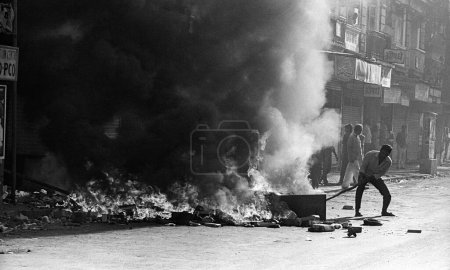 Téléchargez les photos : Les émeutiers ont mis des pneus de voiture de feu après que les fondamentalistes religieux aient démoli le Babri Masjid à Ayodhya dans l'Uttar Pradesh le 6 décembre 1992. L'émeute a continué jusqu'en Janvier 1993 à Bombay maintenant Bombay Mumbai, Maharashtra, Inde - en image libre de droit
